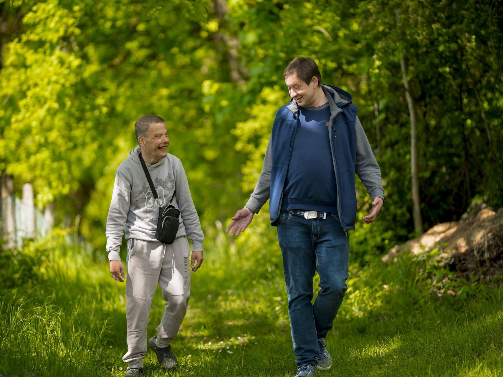 Zwei Männer unterhalten sich bei einem Spaziergang durch den Wald.