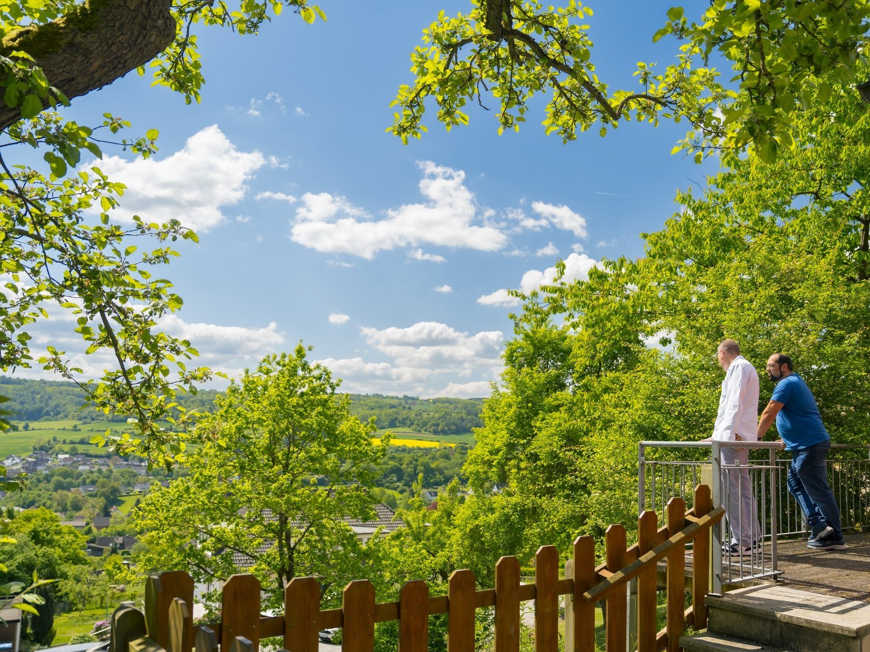Zwei Personen genießen die Aussicht auf Haus Eckberg, das mitten in der Natur liegt.